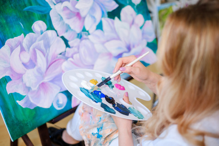 Creative painter paints a colorful picture in her studio.の写真素材