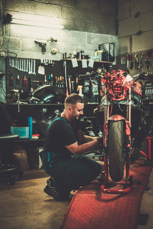 Mechanic arepairing a motorcycle in a workshopの写真素材
