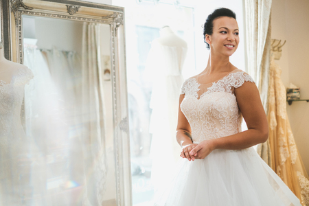 Beautifu bride choosing wedding dress in a wedding salonの写真素材