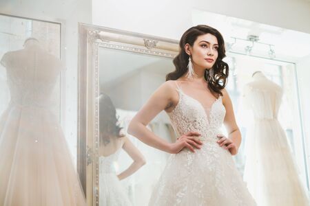 Beautifu bride choosing wedding dress in a wedding salonの写真素材