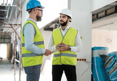 Engineers in hardhats having conversationの写真素材