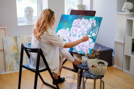 Creative painter paints a colorful picture in her studioの写真素材