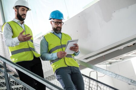 Engineers in hardhats having conversationの写真素材