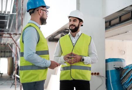 Engineers in hardhats having conversationの写真素材