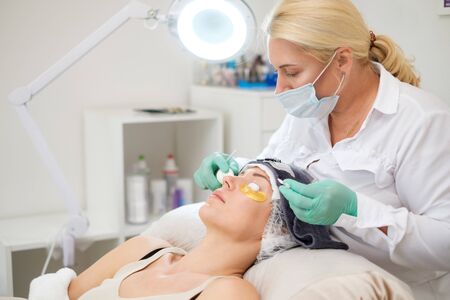 Procedure of eyelash extension in salon by cosmeticianの写真素材
