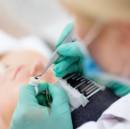 Procedure of eyelash extension in salon by cosmeticianの写真素材