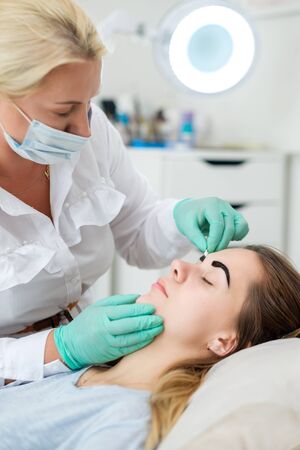 Beautician performing henna brows correctionの写真素材