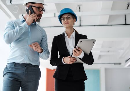 Engineers in hardhats inspecting buildingの写真素材