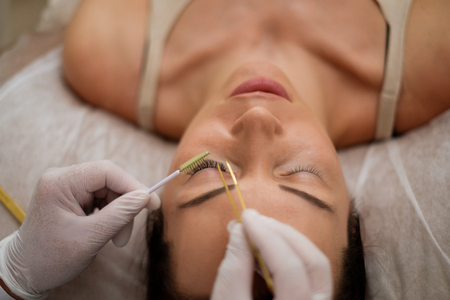 Procedure of eyelash extension in salon by cosmetician