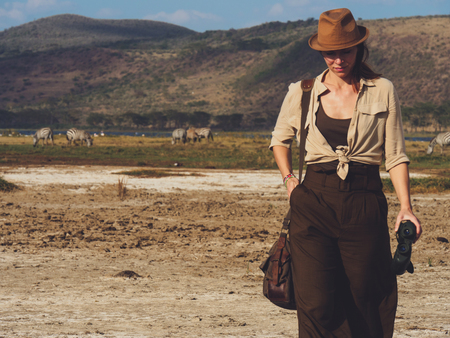 Beautiful woman with binoculars at savanna in Kenyaの写真素材