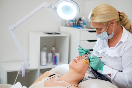 Procedure of eyelash extension in salon by cosmeticianの写真素材