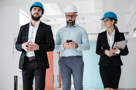 Engineers in hardhats inspecting buildingの写真素材