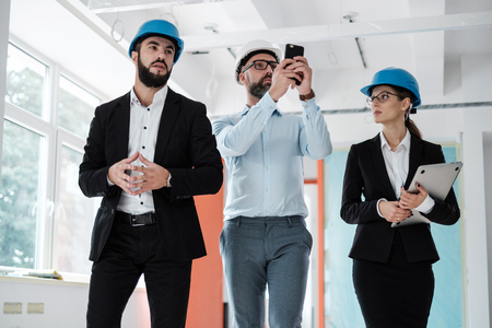 Engineers in hardhats inspecting buildingの写真素材