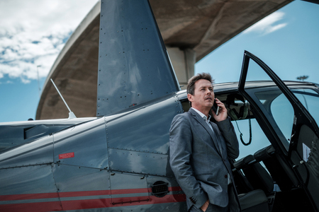 Businessman standing near private helicopterの写真素材