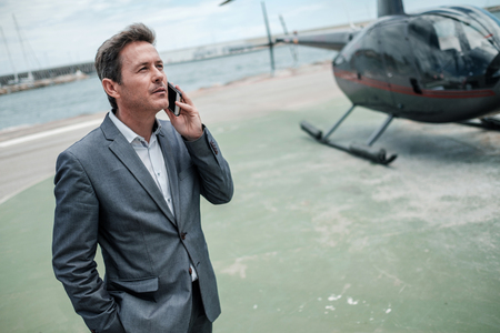 Businessman standing near private helicopterの写真素材