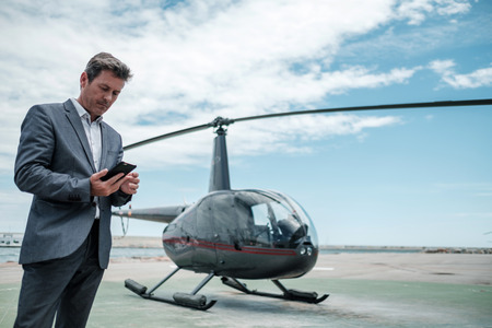 Businessman standing near private helicopterの写真素材
