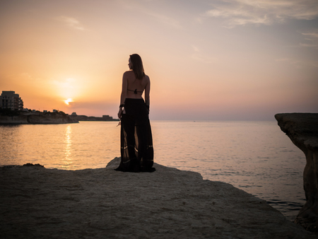 Woman looking on a resort town at duskの写真素材