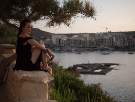 Woman looking on a resort town at duskの写真素材