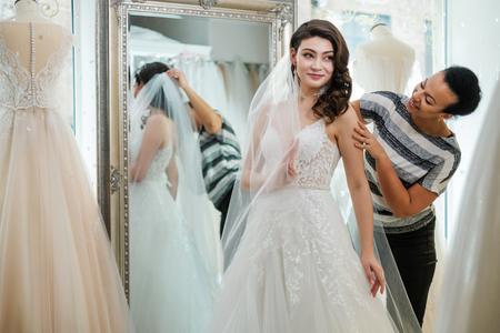Beautifu bride choosing wedding dress in a wedding salonの写真素材