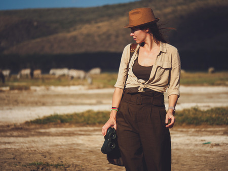Beautiful woman with binoculars at savanna in Kenyaの写真素材