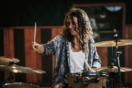 Woman playing drums during music band rehearsalの写真素材