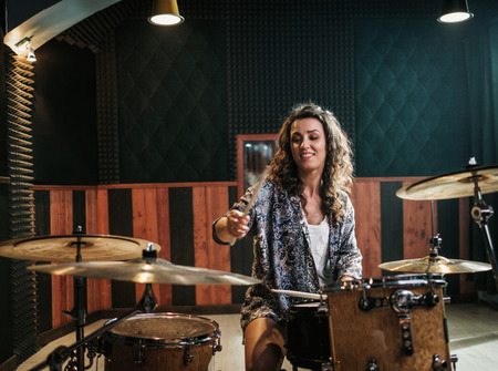 Woman playing drums during music band rehearsalの写真素材