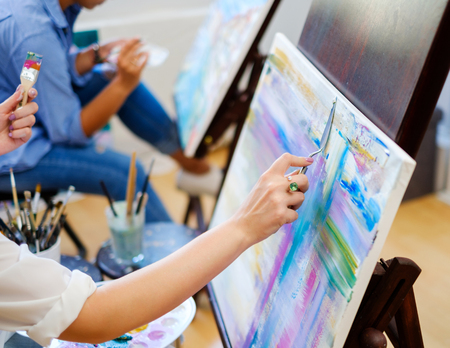 Creative painter and her protege working in a studioの写真素材