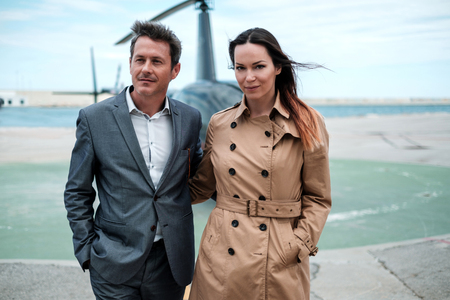 Young business couple near private helicopter