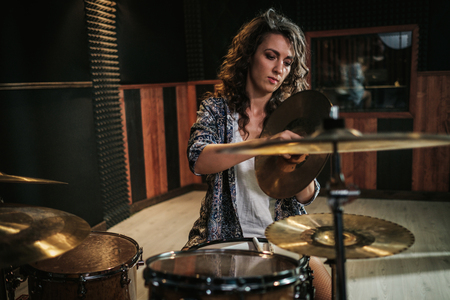 Woman playing drums during music band rehearsalの写真素材