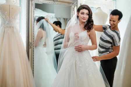 Beautifu bride choosing wedding dress in a wedding salonの写真素材