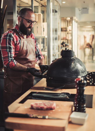 Chef preparing ceramic grill for a steak in a restaurantの写真素材