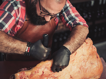 Chef cutting beef carcass in a restaurantの写真素材