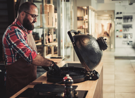 Chef preparing charcoals before grilling in a restaurantの写真素材