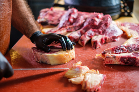 Chef cutting beef steakes in a restaurantの写真素材