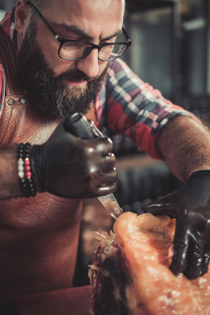 Chef cutting beef carcass in a restaurantの写真素材