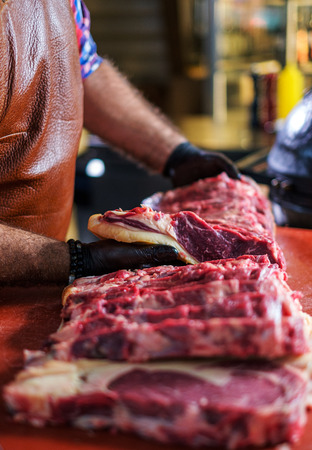 Chef cutting beef steakes in a restaurantの写真素材