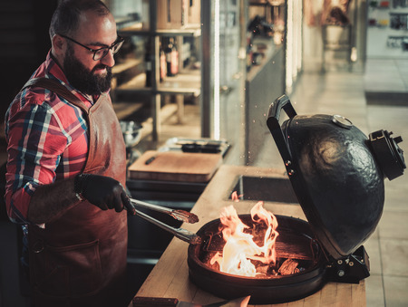 Chef preparing charcoals before grilling in a restaurantの写真素材