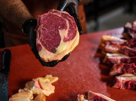 Chef cutting beef steakes in a restaurantの写真素材