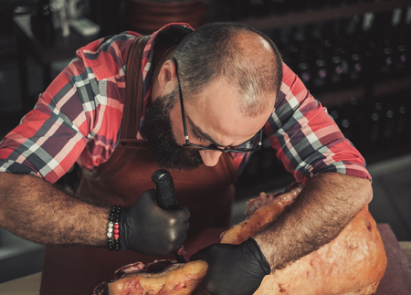 Chef cutting beef carcass in a restaurantの写真素材