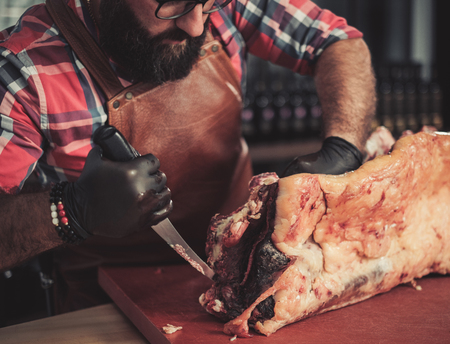 Chef cutting beef carcass in a restaurantの写真素材