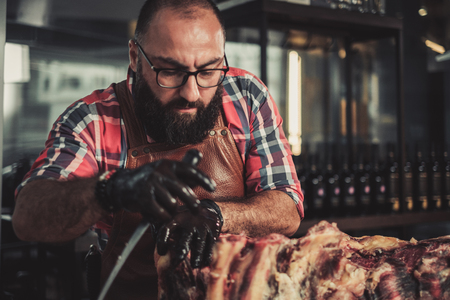 Chef cutting beef carcass in a restaurantの写真素材