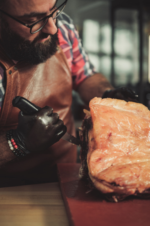 Chef cutting beef carcass in a restaurantの写真素材
