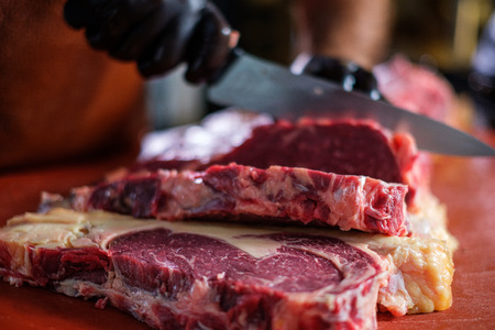 Chef cutting beef steakes in a restaurantの写真素材