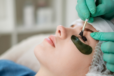 Beautician performing henna eyelashes correctionの写真素材