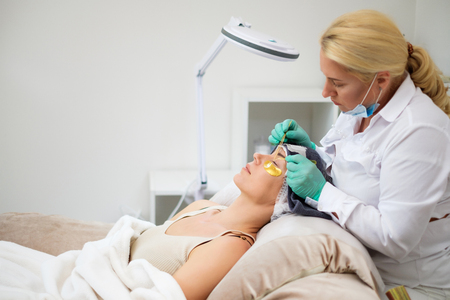 Procedure of eyelash extension in salon by cosmeticianの写真素材