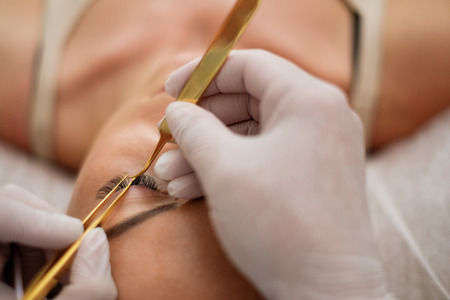 Procedure of eyelash extension in salon by cosmeticianの写真素材