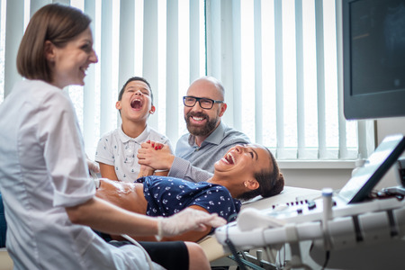 Pregnant woman and her family on utltrasonographic examination at hospitalの写真素材