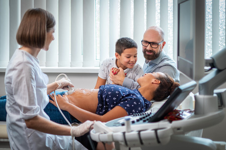 Pregnant woman and her family on utltrasonographic examination at hospital