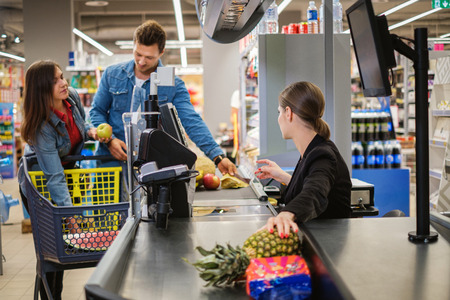 Young couple buying goods in a grocery storeの写真素材