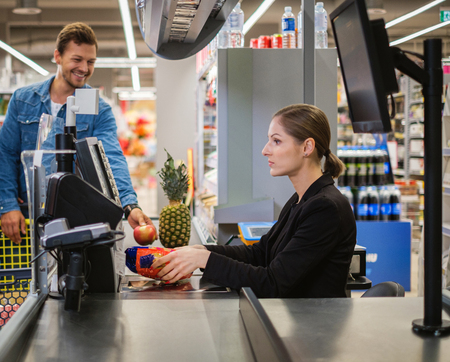 Young couple buying goods in a grocery storeの写真素材